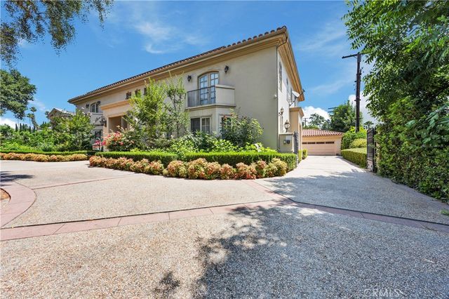 a front view of a house with a yard and potted plants