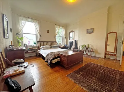 a spacious bedroom with a bed a couch and a large window