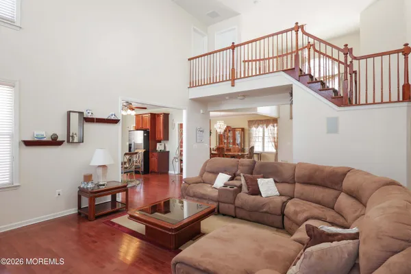 a kitchen with stainless steel appliances granite countertop a sink dishwasher a dining table and chairs with wooden floor