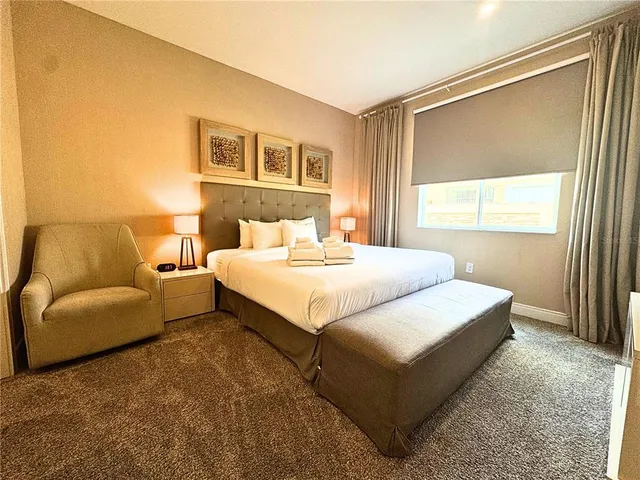 a large bed sitting in a bedroom next to a lamp