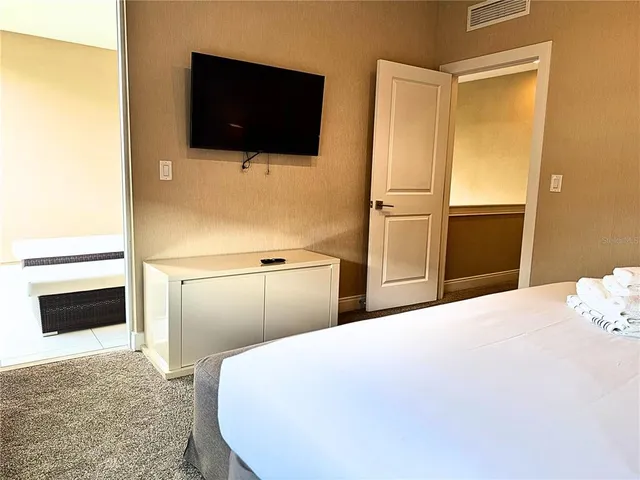 a bedroom with a bed and flat screen tv