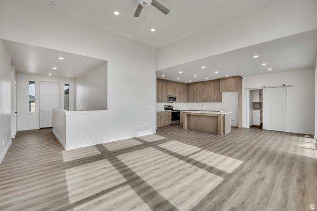 3839 West 825 North, Unit WF18 West Point, UT 84015 - Photo 6 of 22 Unfurnished living room with a barn door, recessed lighting, a ceiling fan, and light wood-type flooring