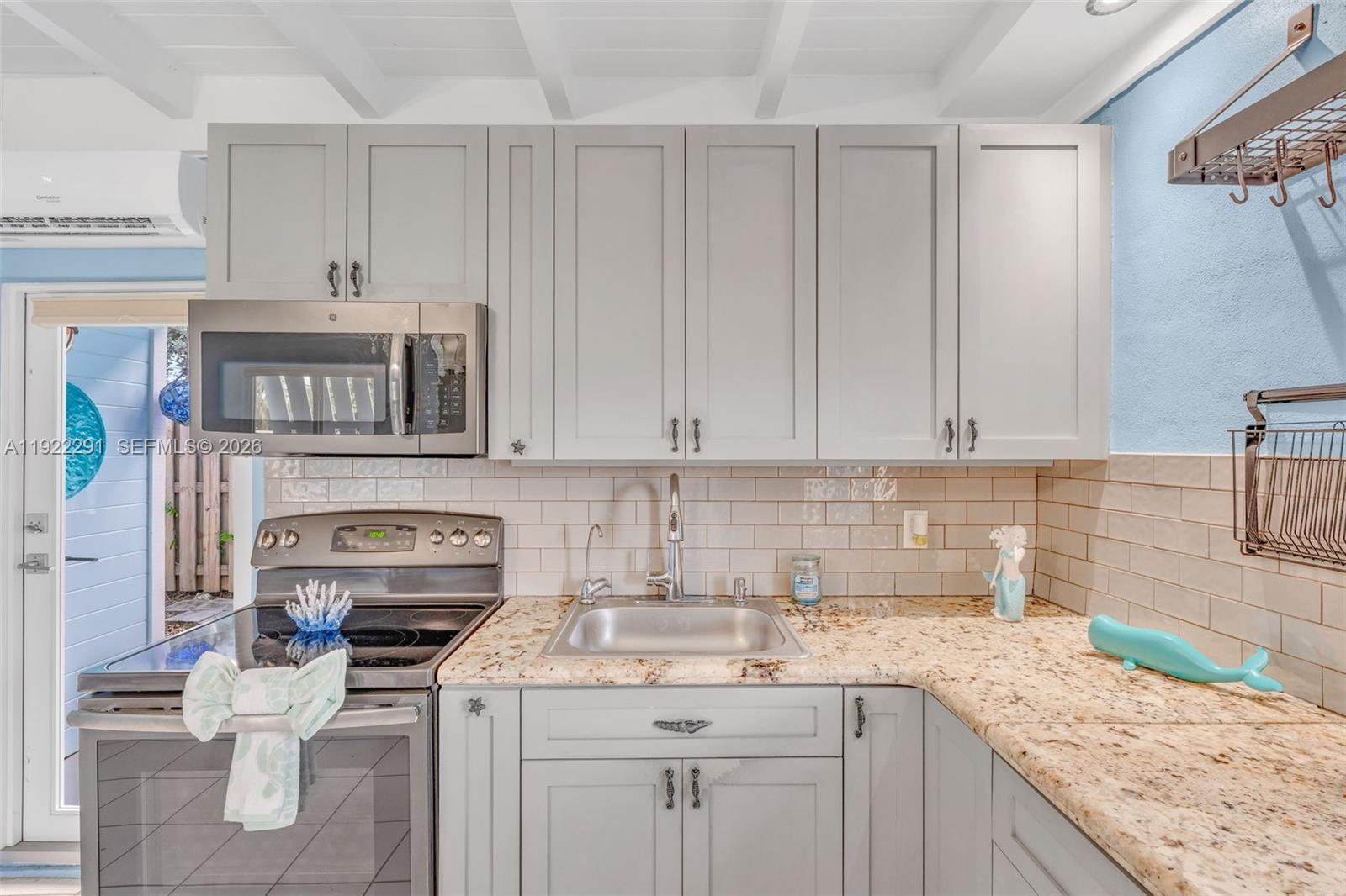 40 Pirates Drive Key Largo, FL 33037 - Photo 14 of 38 a kitchen with stainless steel appliances granite countertop a sink stove and cabinets