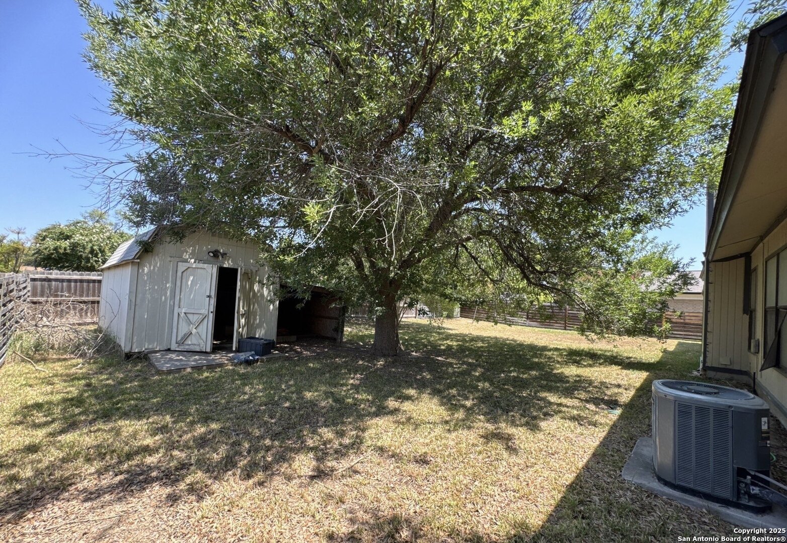 5303 Walnut Vista Drive San Antonio, TX 78247 - Photo 17 of 18 a view of a backyard with large trees and a small yard