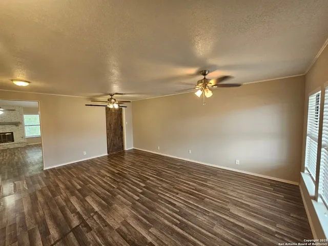 a view of a livingroom with a ceiling fan and wooden floor