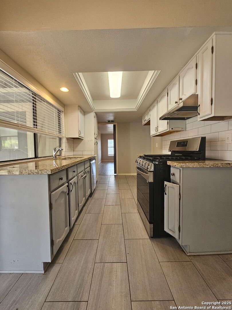 5303 Walnut Vista Drive San Antonio, TX 78247 - Photo 6 of 18 a kitchen with stainless steel appliances granite countertop a stove a sink dishwasher and a refrigerator
