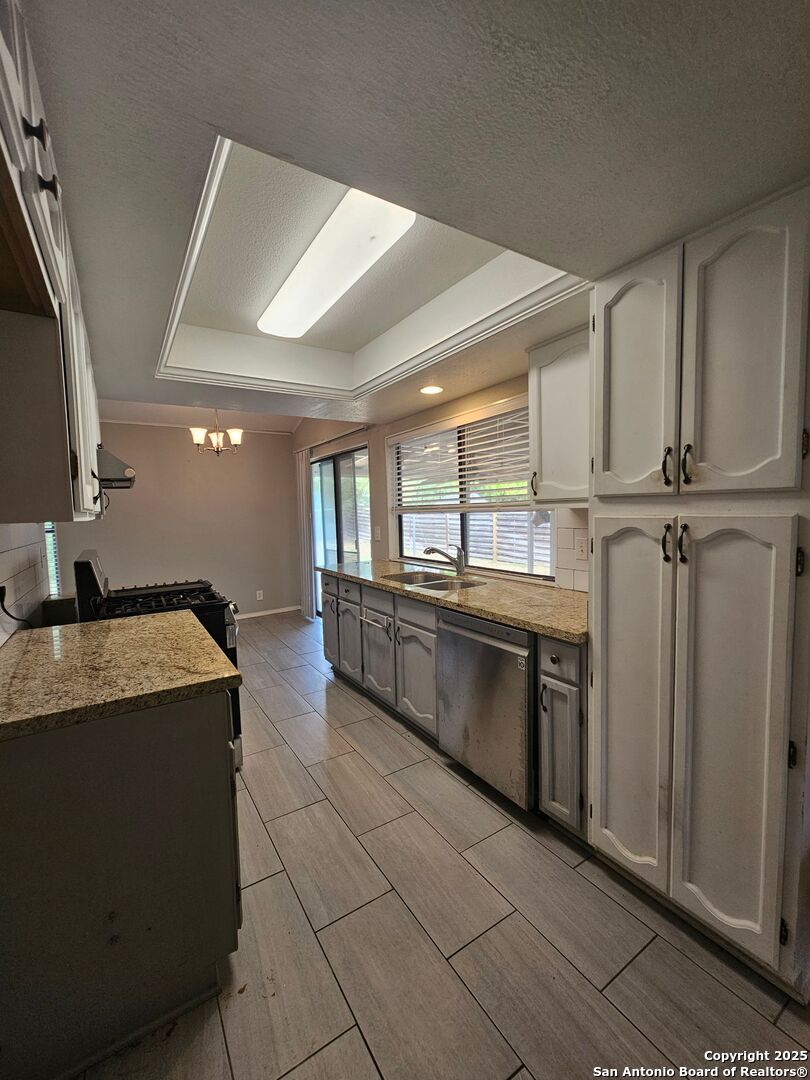 5303 Walnut Vista Drive San Antonio, TX 78247 - Photo 7 of 18 a large kitchen with granite countertop a sink a counter top space and stainless steel appliances