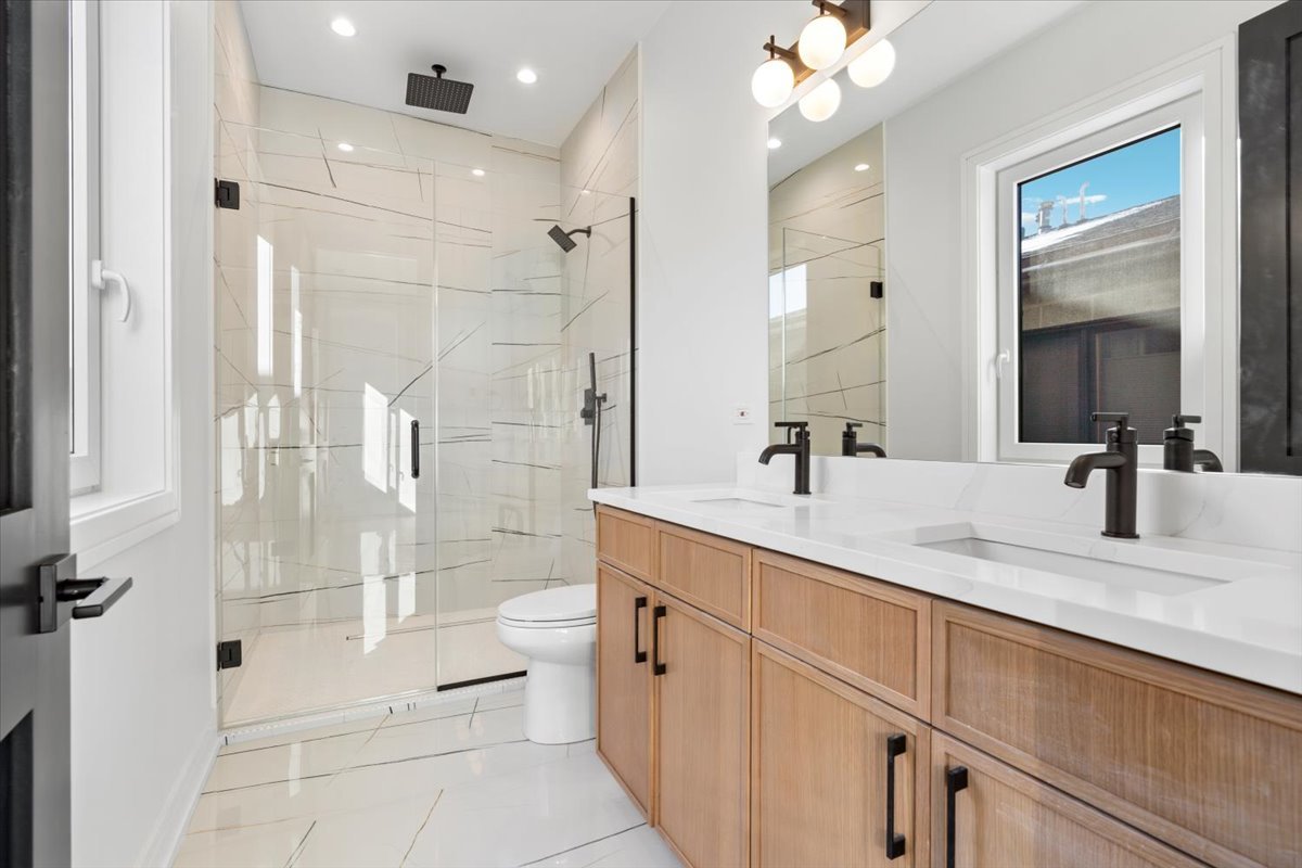 2636 West Evergreen Avenue, Unit 3 Chicago, IL 60622 - Photo 14 of 22 a bathroom with a double vanity sink mirror double shower and a toilet