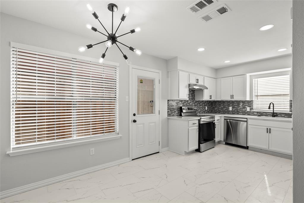 7418 Tulane Drive, Unit B Rowlett, TX 75088 - Photo 1 of 1 a kitchen with granite countertop a white stove top oven cabinets and a window