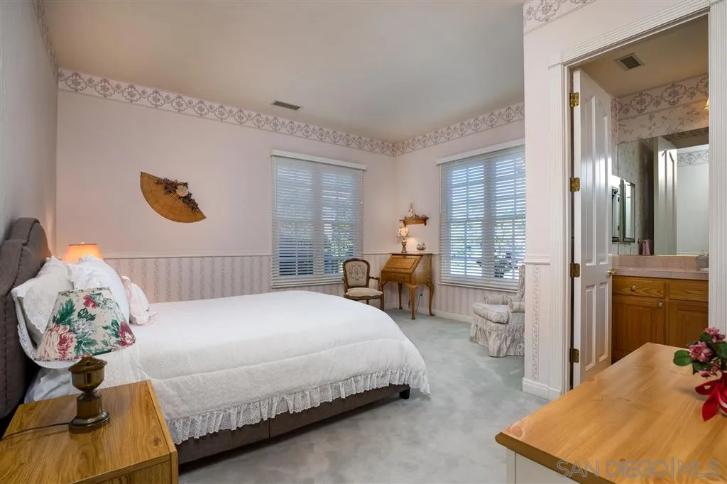 12966 Lomas Verdes Drive Poway, CA 92064 - Photo 22 of 25 a bedroom with a bed and a chandelier