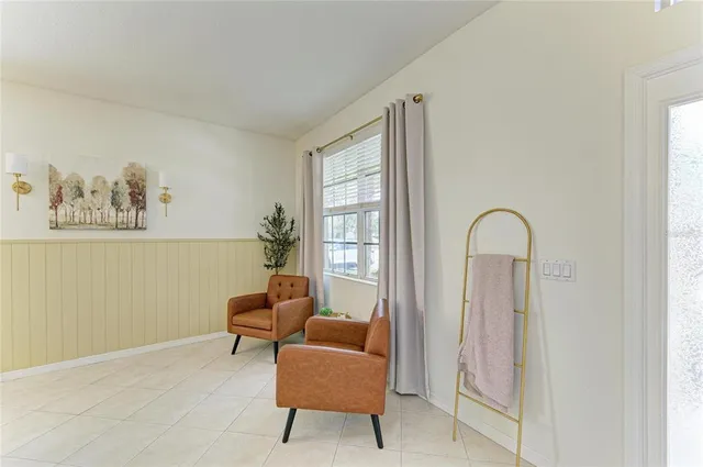 a living room with furniture and a floor to ceiling window