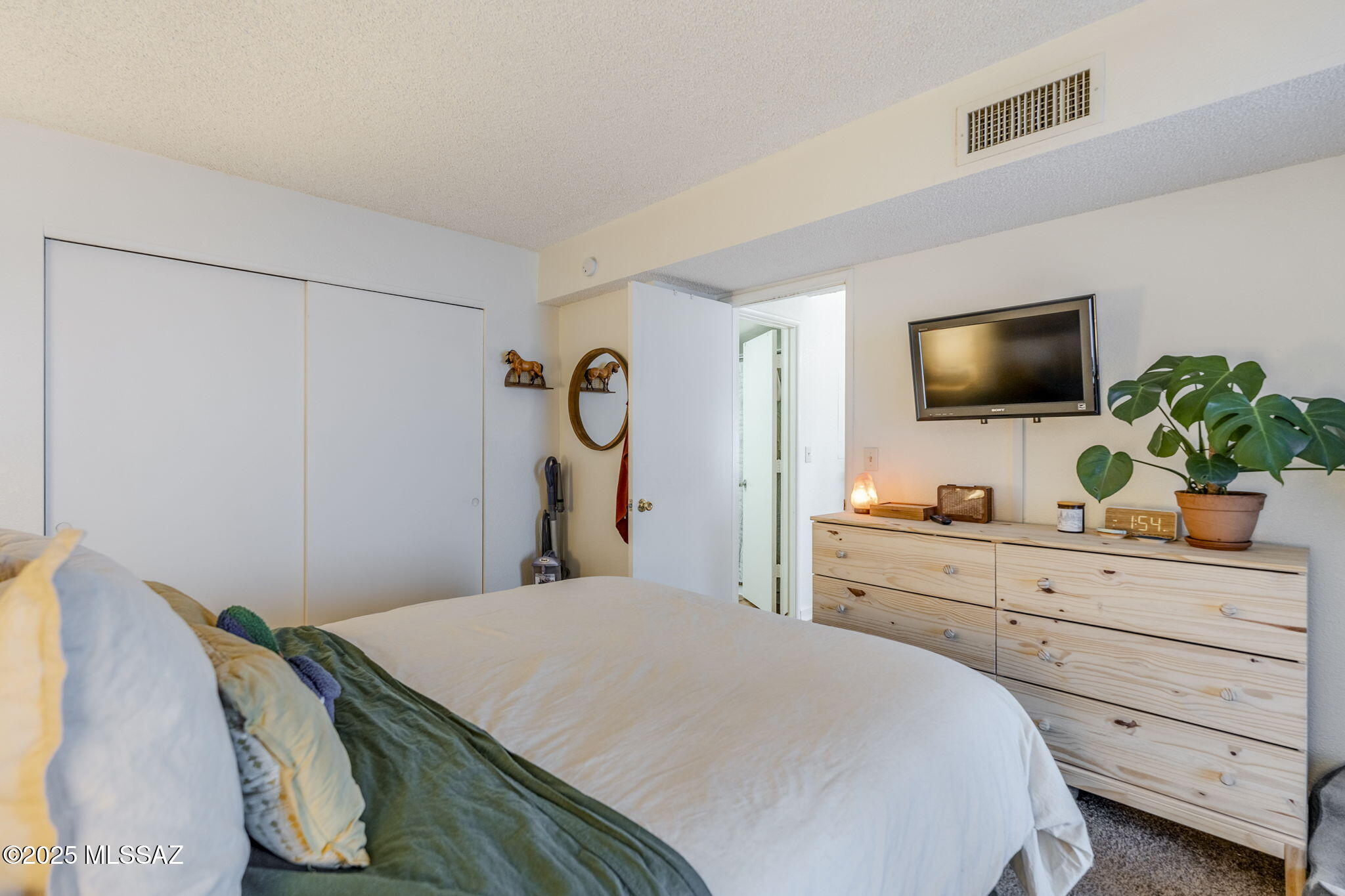 1131 West Roger Road Tucson, AZ 85705 - Photo 16 of 26 a bedroom with a bed and a flat screen tv