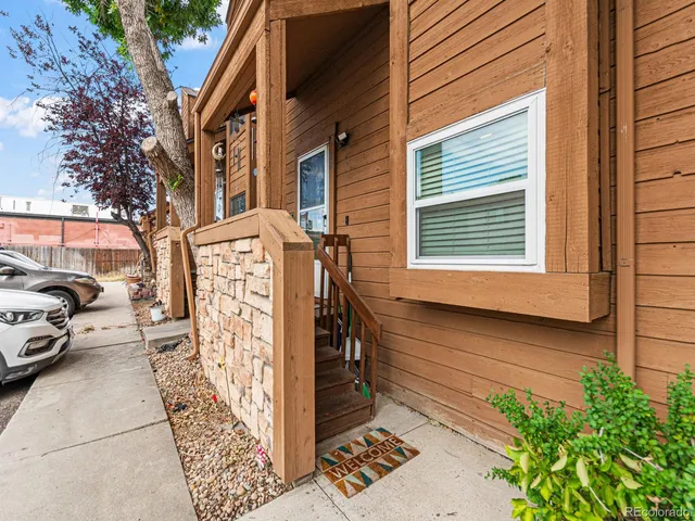 a view of a street with cars parked in front of a house