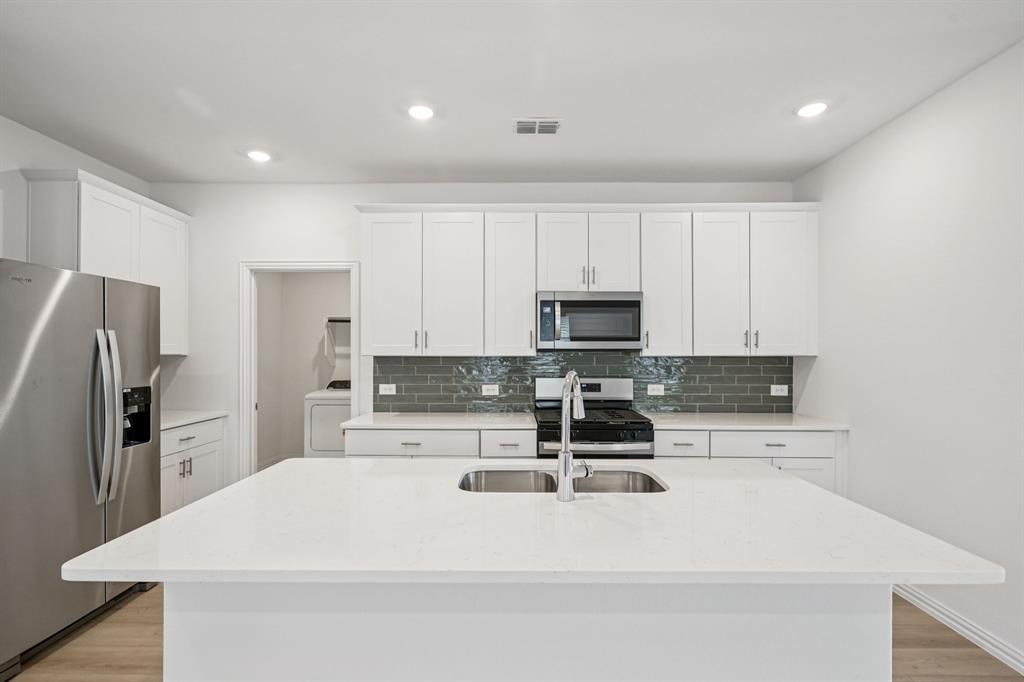 522 Blanton Street McKinney, TX 75069 - Photo 1 of 1 a kitchen with stainless steel appliances a stove a sink a refrigerator a window