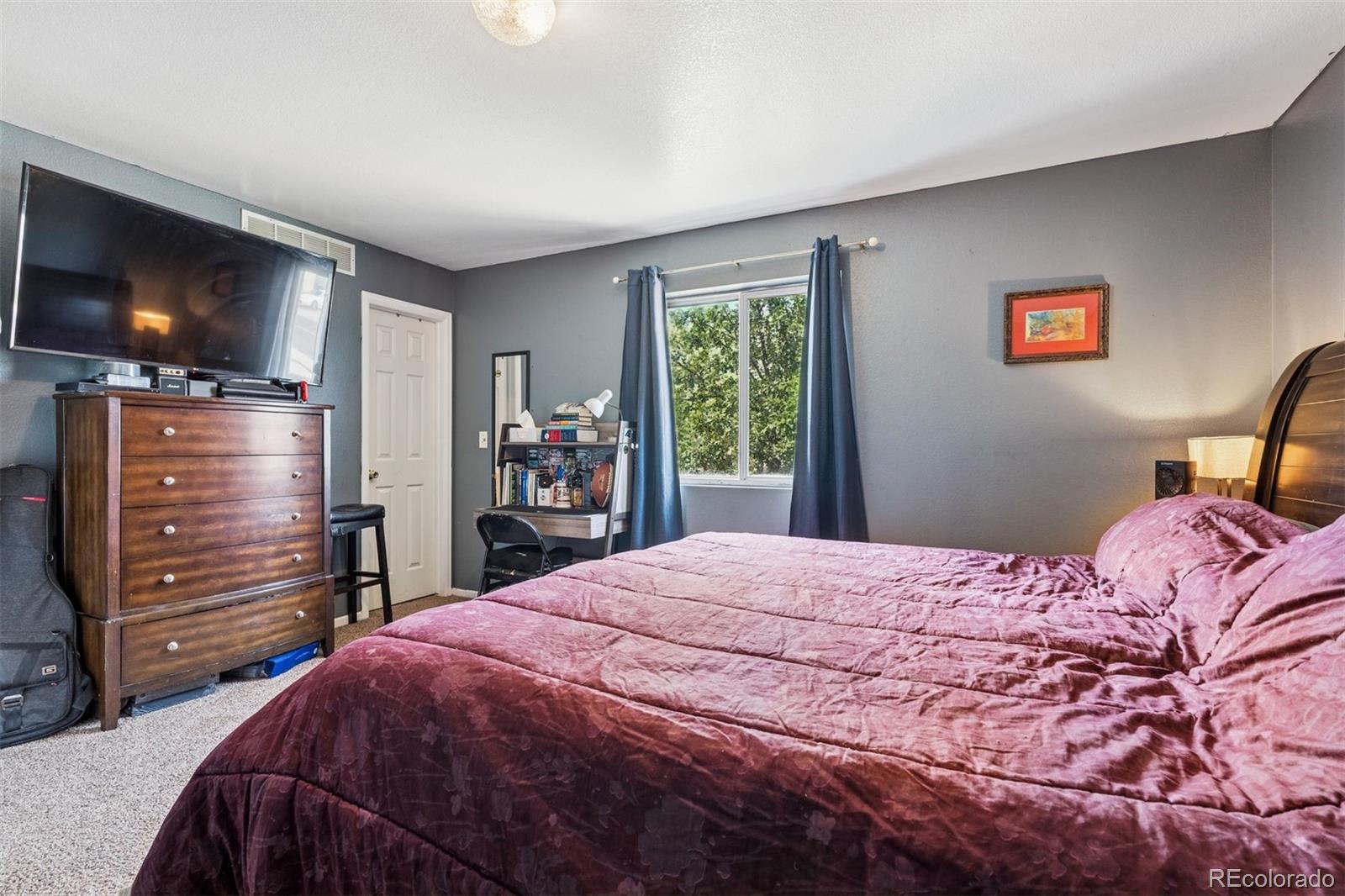 3820 Riverside Parkway Evans, CO 80620 - Photo 13 of 25 a bedroom with a bed and a flat screen tv