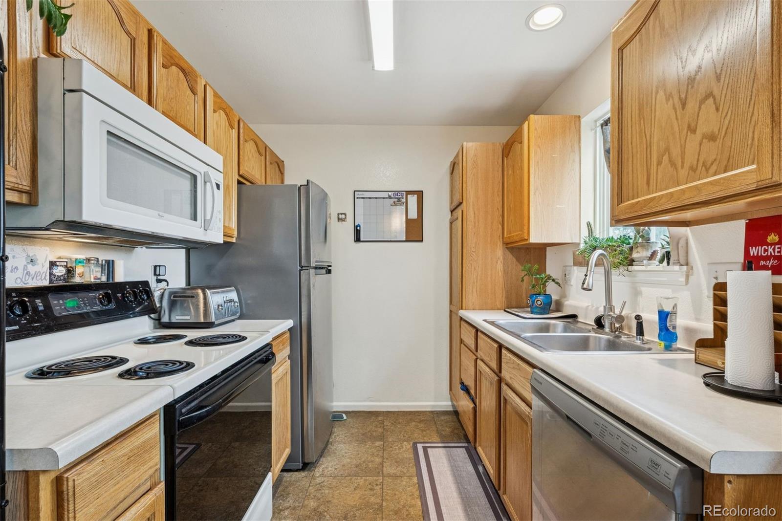 3820 Riverside Parkway Evans, CO 80620 - Photo 8 of 25 a kitchen with stainless steel appliances a stove a sink dishwasher a refrigerator and cabinets with wooden floor