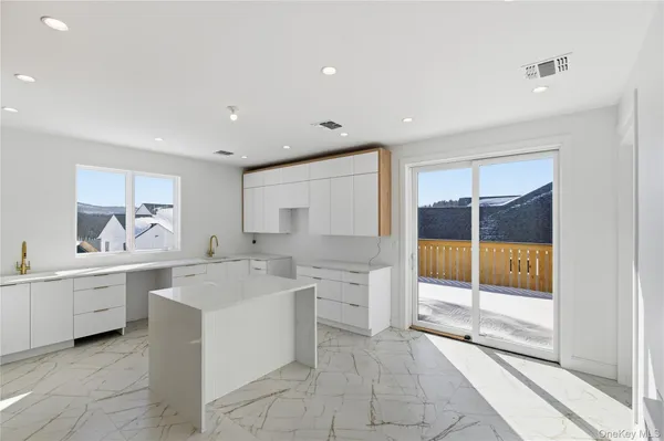 a large white kitchen with a sink and cabinets