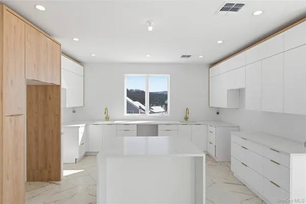 a kitchen with white cabinets and window