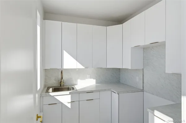 a kitchen with stainless steel appliances a sink a stove and white cabinets