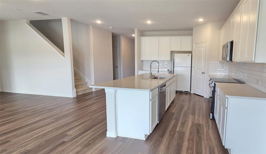 916 Elizabeth Street Anna, TX 75409 - Photo 5 of 31 a large kitchen with a large counter top a sink a window and stainless steel appliances