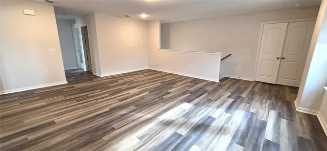 an empty room with windows and closet