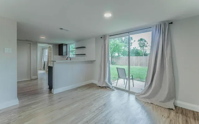 a view of a kitchen with wooden floor and outdoor space