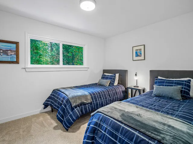 a bedroom with two beds and a large window