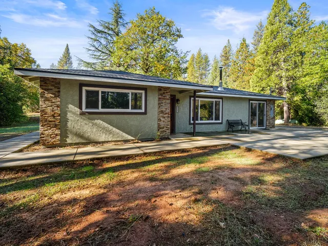 a view of a house with a backyard and a tree
