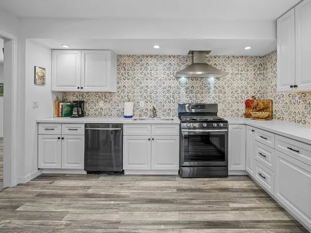 a kitchen with a stove and white cabinets