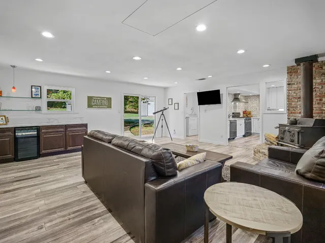 a living room with stainless steel appliances furniture stove and kitchen view