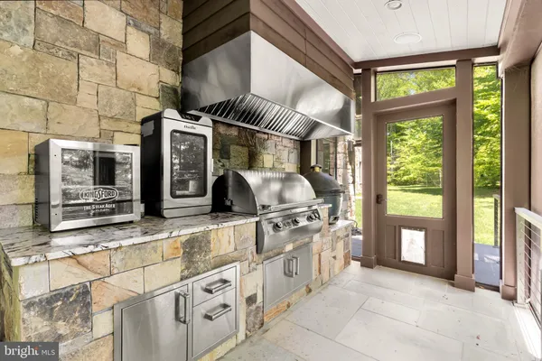 a view of a kitchen with stainless steel appliances granite countertop a stove and a large window