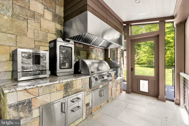 a view of a kitchen with stainless steel appliances granite countertop a stove and a large window