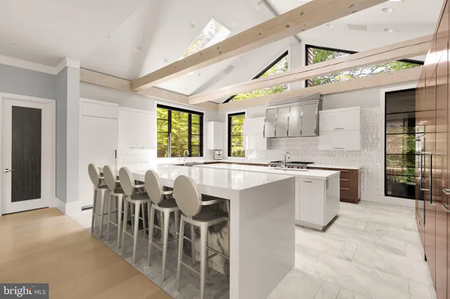 a large white kitchen with lots of counter space and windows