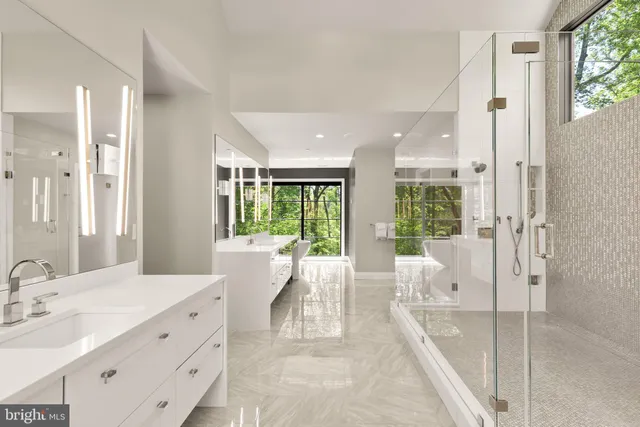 a large white room with a large window and stainless steel appliances