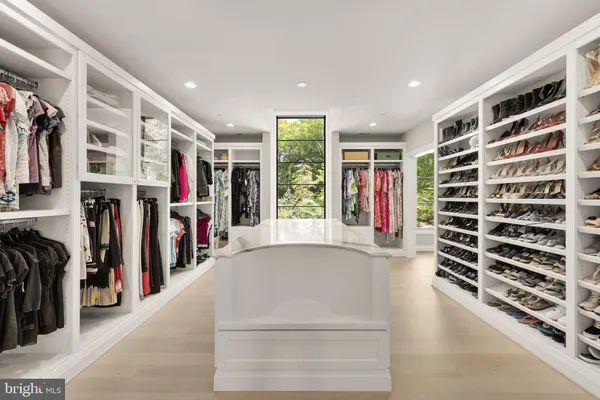a view of walk in closet with clothes and shoes