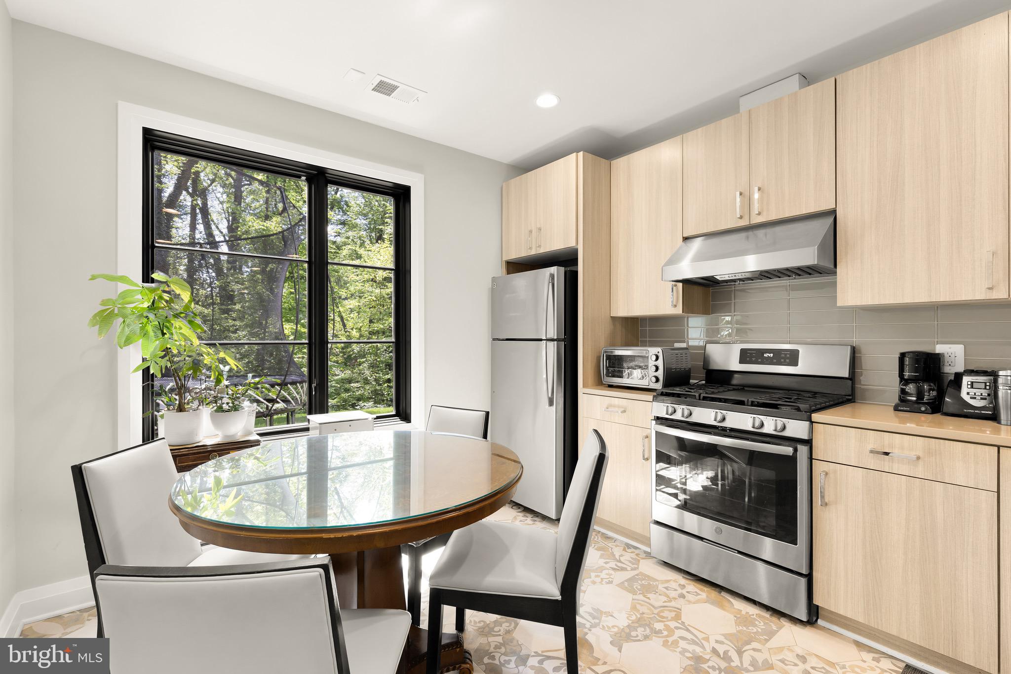 3 Bay Tree Lane Bethesda, MD 20816 - Photo 41 of 50 a kitchen with stainless steel appliances a stove a table and chairs