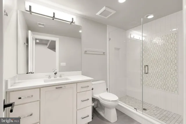 a bathroom with a toilet a sink a mirror and shower