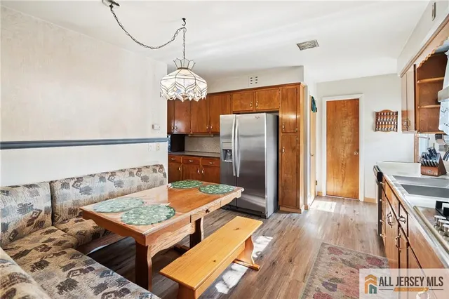 a kitchen with stainless steel appliances granite countertop a refrigerator a stove and a wooden floors