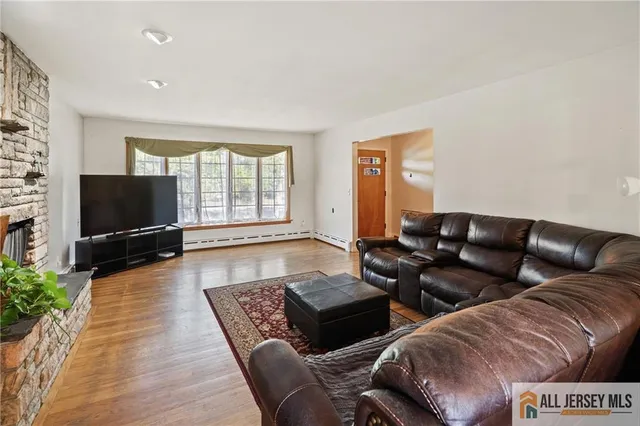 a living room with furniture wooden floor and a flat screen tv