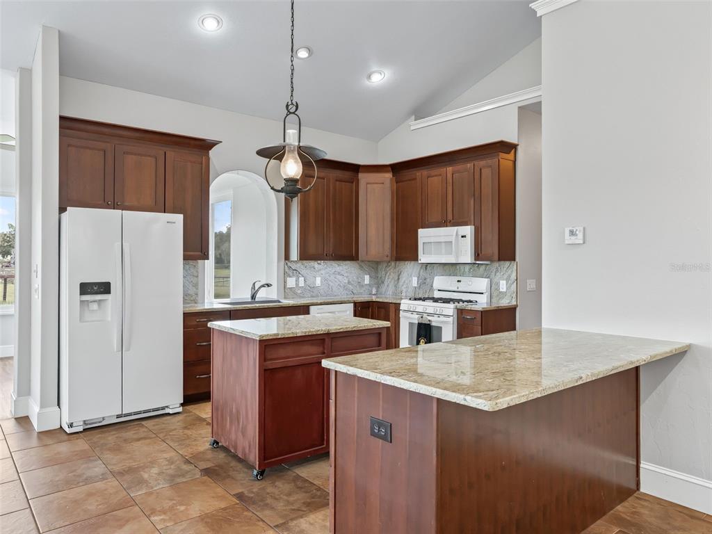 402 Southwest 127th Place Ocala, FL 34473 - Photo 16 of 75 a kitchen with a refrigerator a sink and cabinets