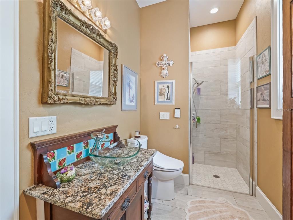 402 Southwest 127th Place Ocala, FL 34473 - Photo 37 of 75 a bathroom with a granite countertop sink a toilet and shower