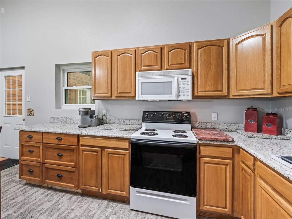 402 Southwest 127th Place Ocala, FL 34473 - Photo 55 of 75 a kitchen with granite countertop a sink stove and cabinets