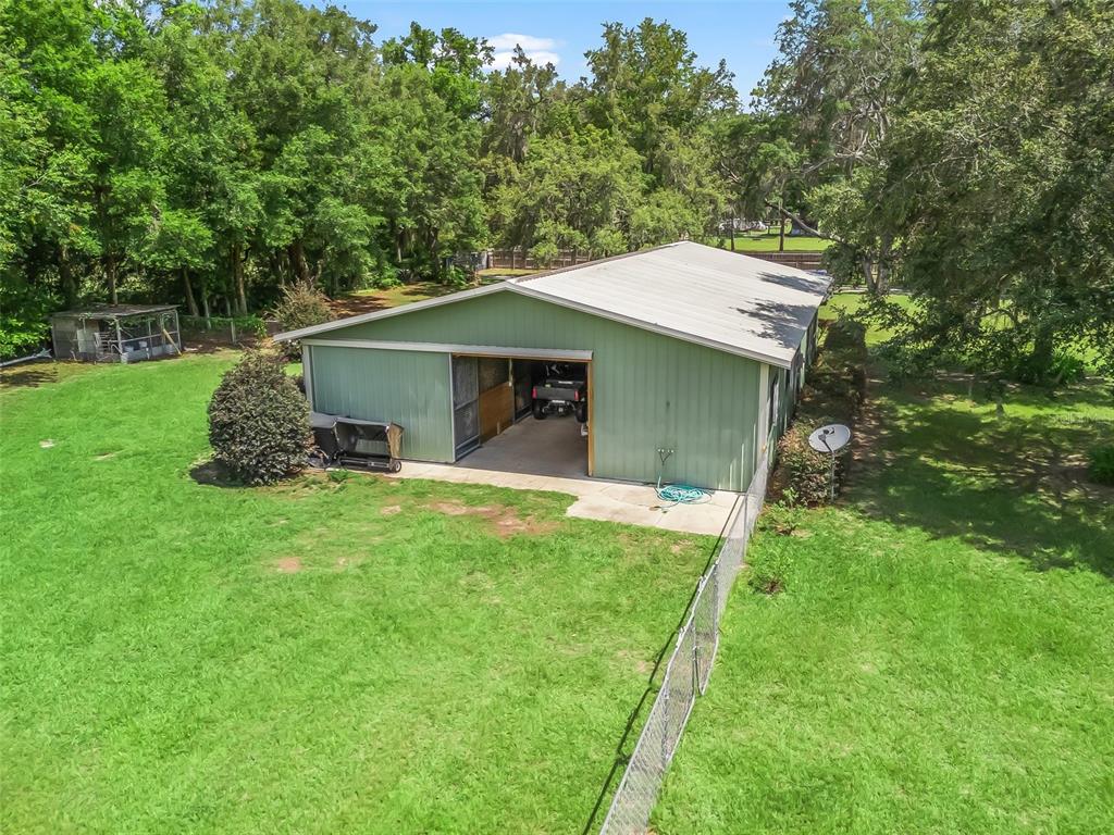 402 Southwest 127th Place Ocala, FL 34473 - Photo 69 of 75 a backyard of a house with table and chairs under an umbrella