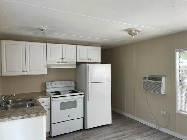 a kitchen with granite countertop white cabinets and white appliances