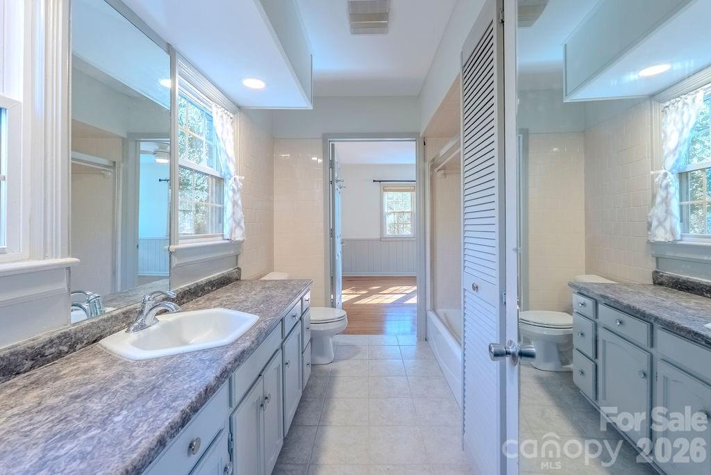 2212 Wayah Road Franklin, NC 28734 - Photo 16 of 47 a bathroom with a granite countertop double vanity sink a mirror and a toilet