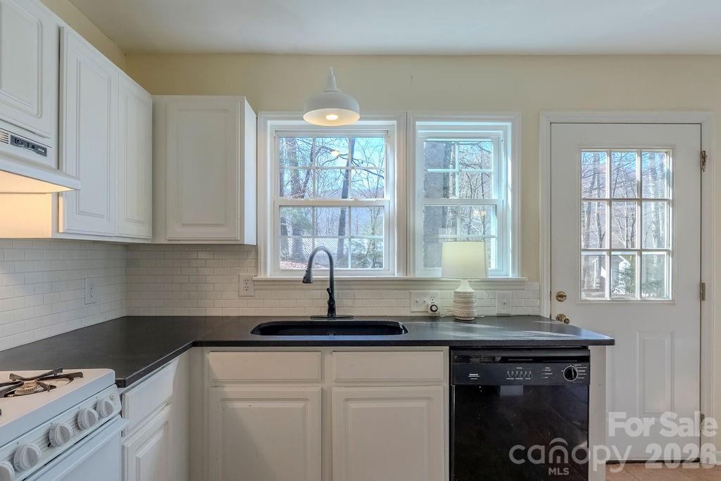 2212 Wayah Road Franklin, NC 28734 - Photo 26 of 47 a kitchen with granite countertop a sink a stove and cabinets