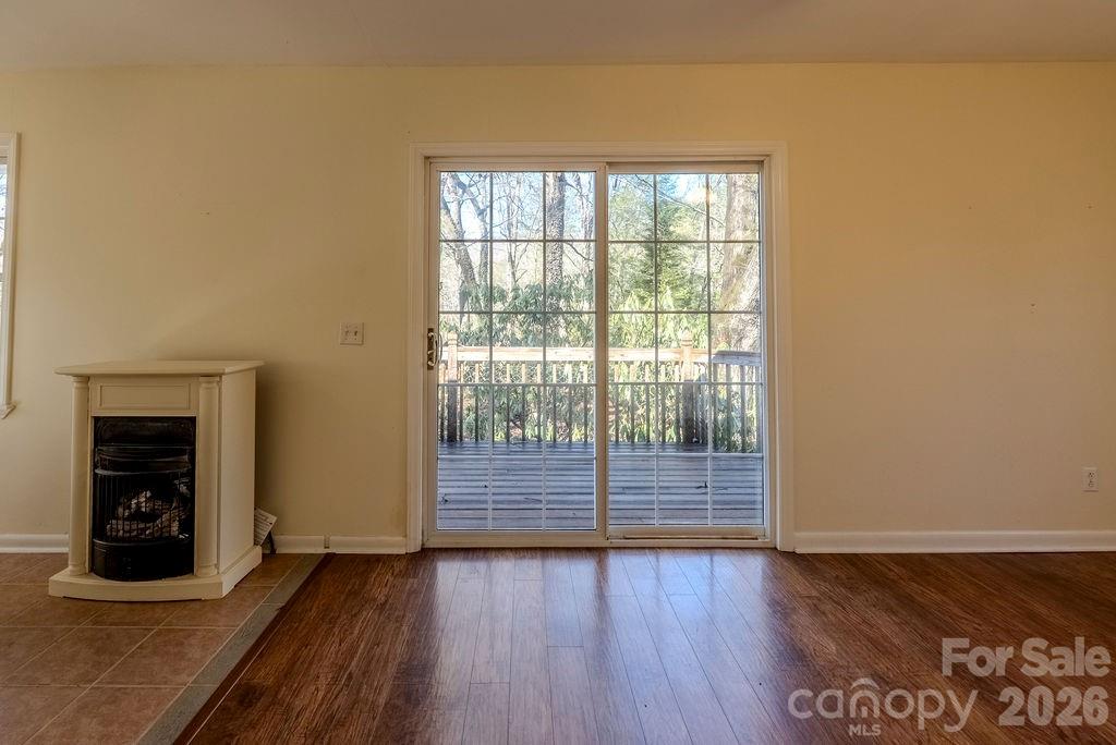 2212 Wayah Road Franklin, NC 28734 - Photo 28 of 47 an empty room with wooden floor and fireplace