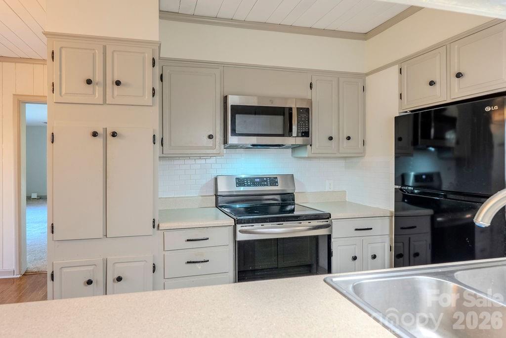 2212 Wayah Road Franklin, NC 28734 - Photo 4 of 47 a kitchen with white cabinets and stainless steel appliances