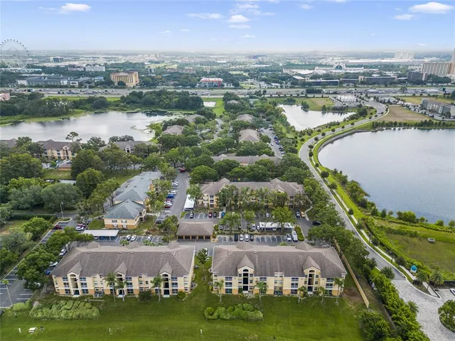 an aerial view of residential houses with outdoor space and lake view