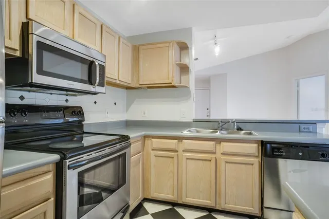 a kitchen with stainless steel appliances granite countertop a stove microwave and sink
